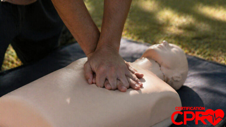 Person performing hands-only CPR on a mannequin outdoors in West Palm Beach.